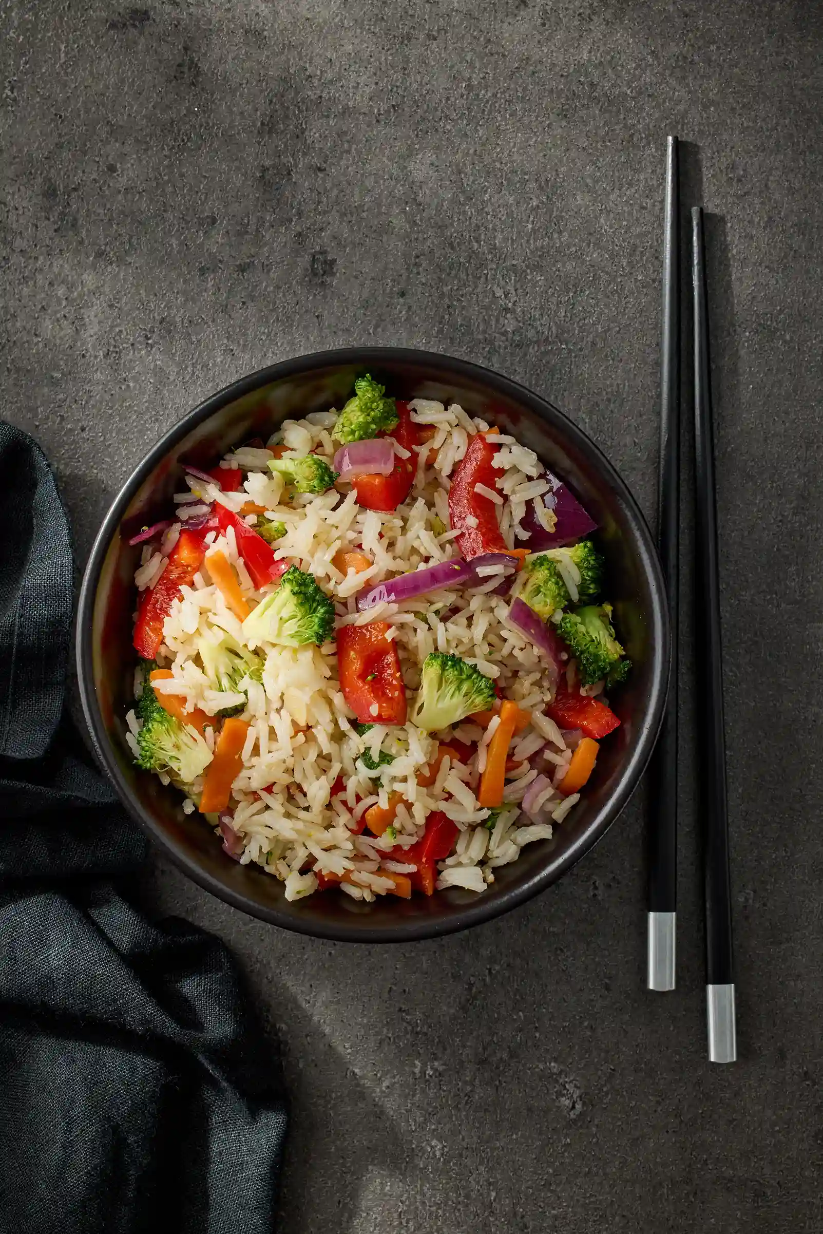 bowl de arroz con verduras y palillos a el lado derecho