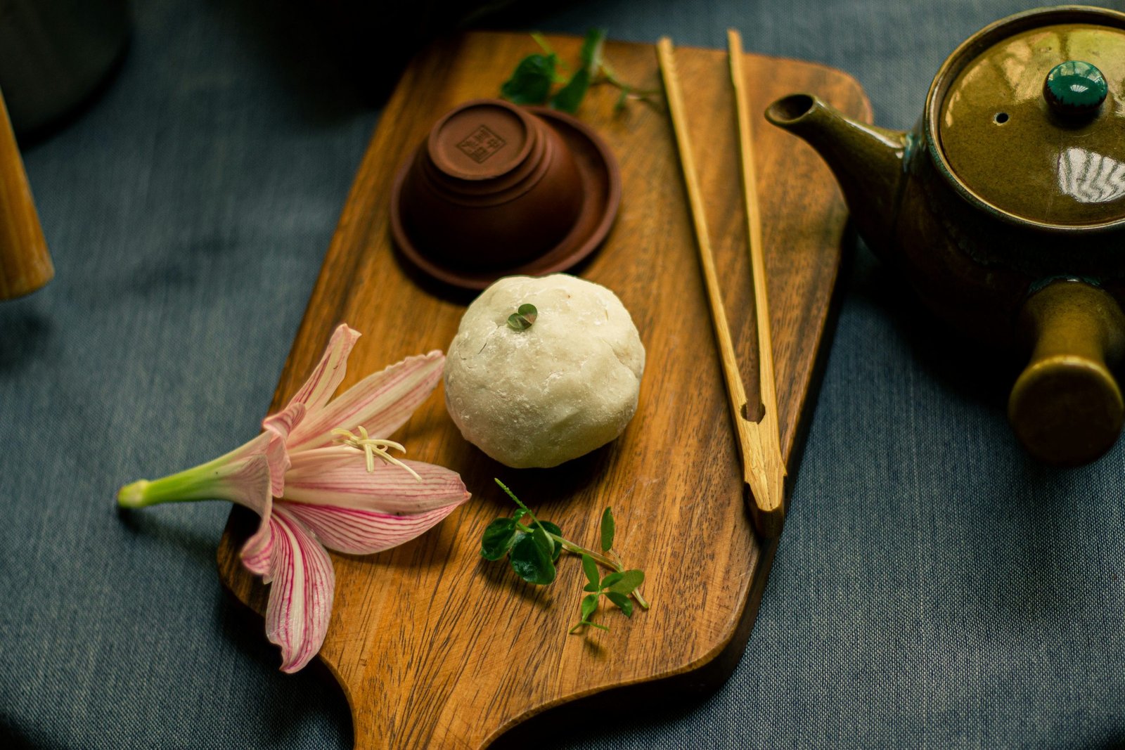 mochi sobre una mesa de madera, con palillos y una flor de decoración