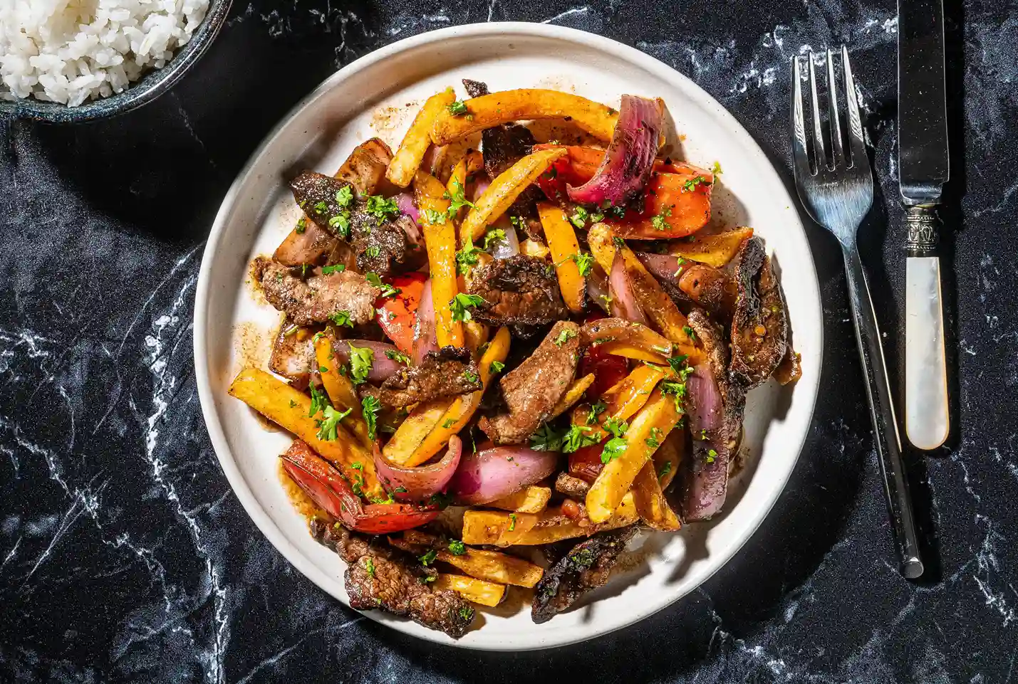 plato con carne cortada y verduras salteadas